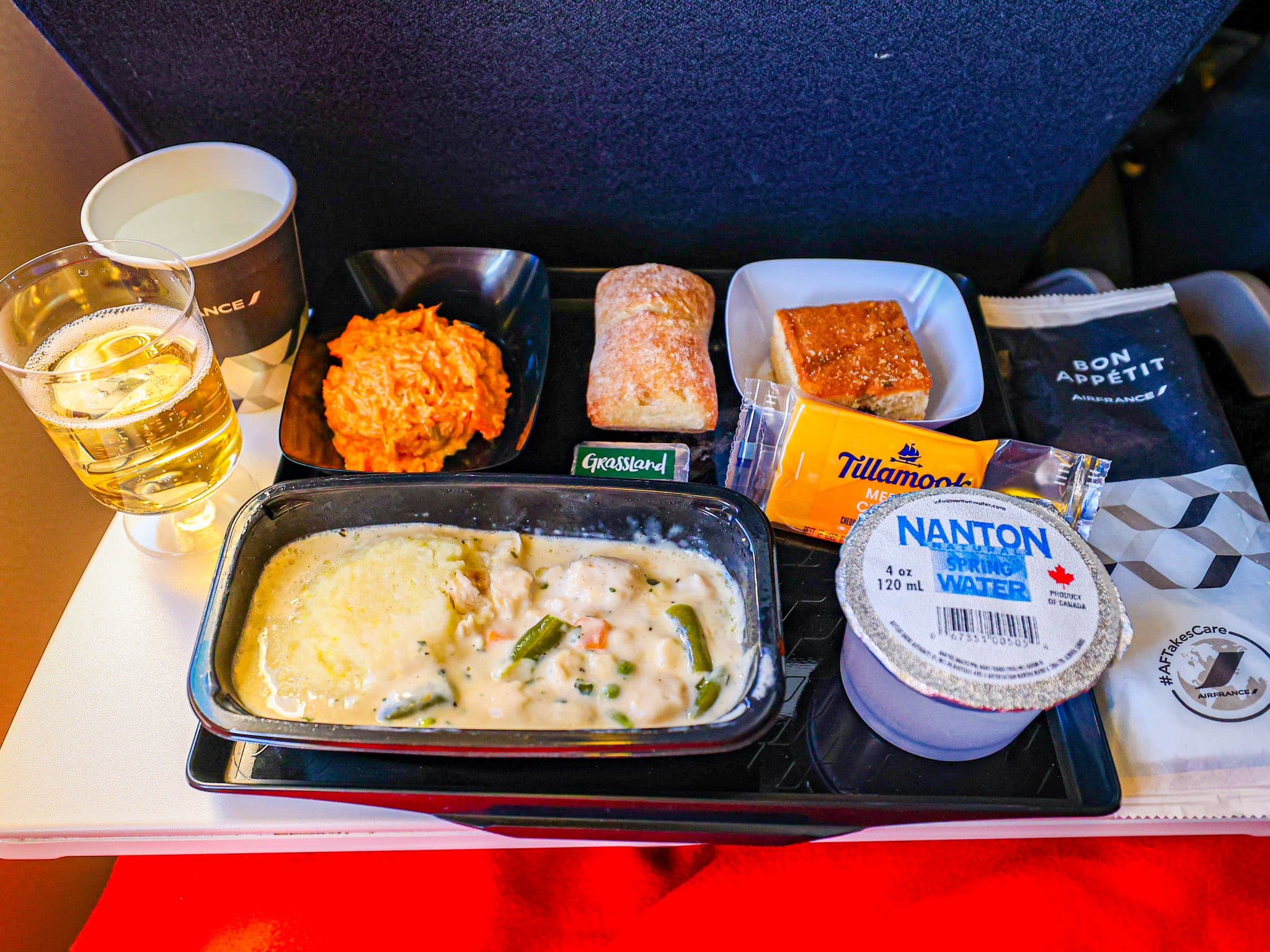 Air France economy class meal tray on a long-haul Boeing 777, showing starter, main course, bread and dessert