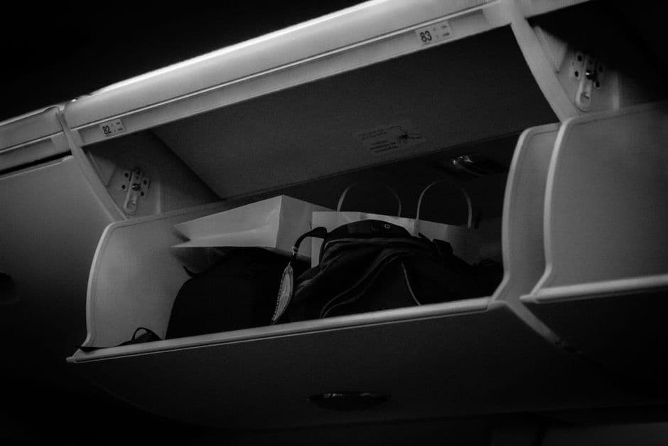 Japan Airlines overhead storage bins carry-on luggage in airplane cabin