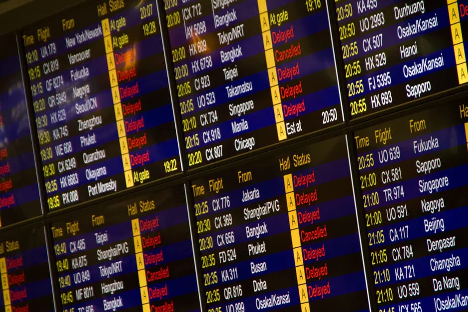 Airport departure board showing flight delays and cancellations
