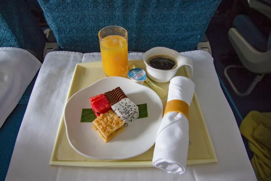 JAL Economy Class meal tray on a Tokyo Narita to Guam flight showing rice, side dishes and dessert