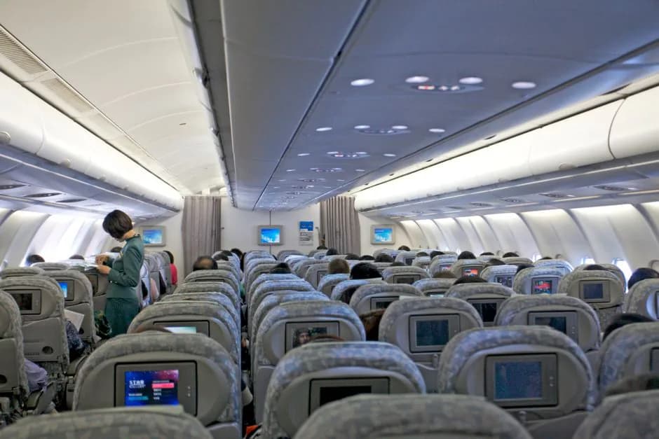 Japan Airlines Boeing 767-300 economy class cabin interior showing overhead bins and passenger seats