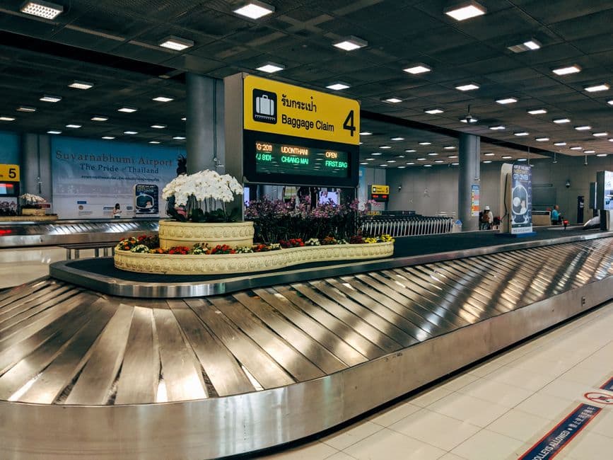 Checked baggage suitcases on an airport conveyor belt at a Japanese international airport